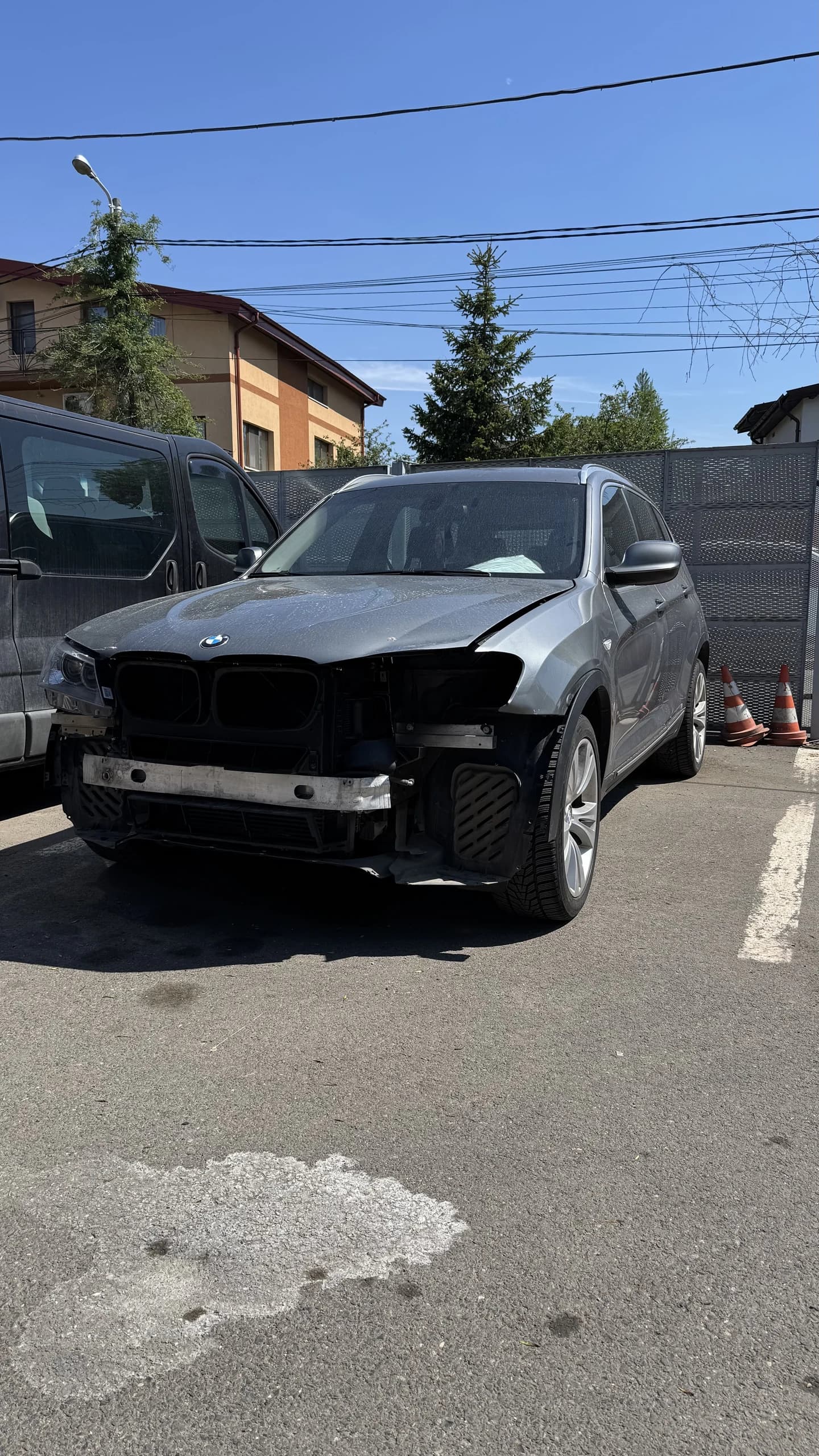 Autoturism cu bara frontală demontată în curtea atelierului AutoRun